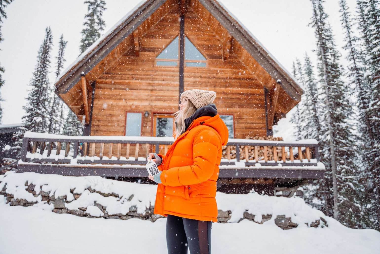 Image of person outside in the snow wearing an orange jacket